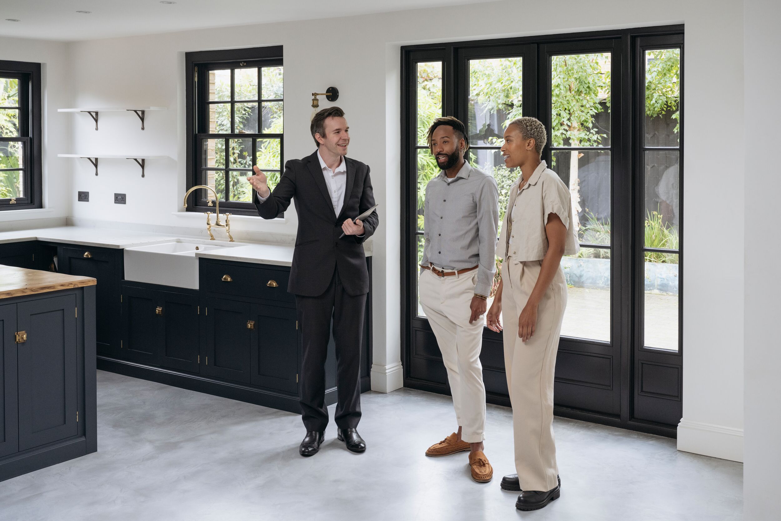 Adult Black couple enjoying tour of luxury home interior.